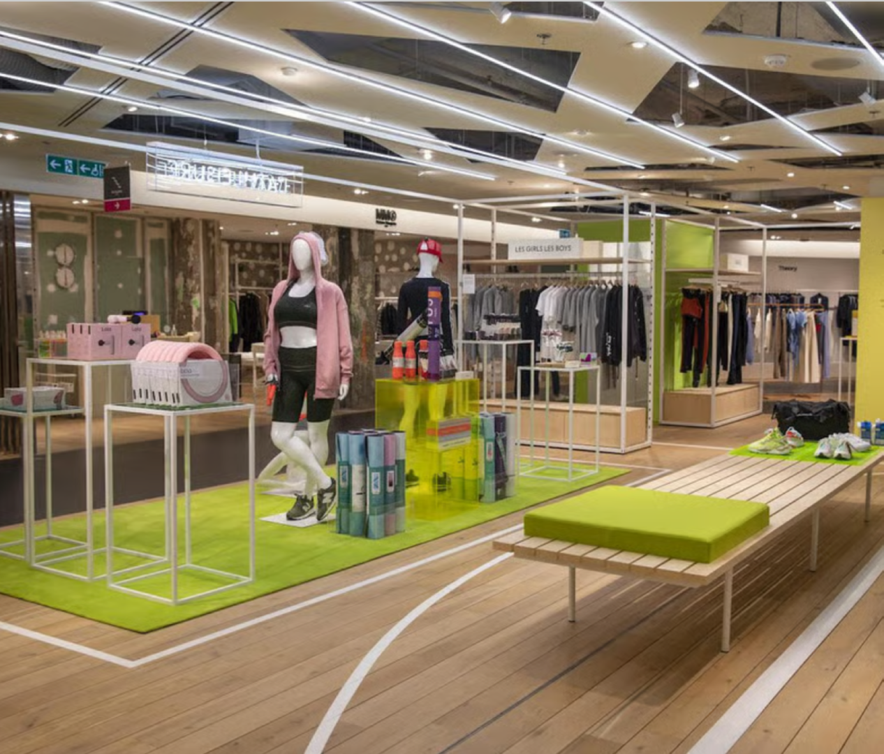 The athleisure floor at Printemps Nation: mannequins on a green running-track rug, open rails and pale timber flooring